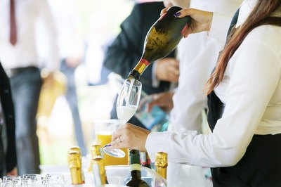 A server pours champagne at an event.
