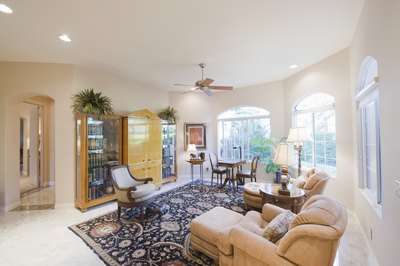 A carpeted living room has a large area rug on it.