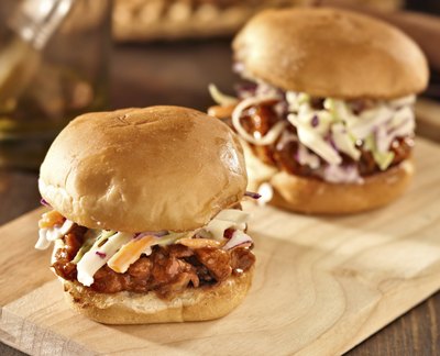 Pulled pork sliders on a a wood cutting board.