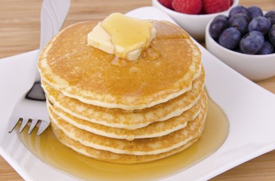 Stack of pancakes with butter and syrup.