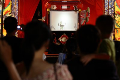 Spectators watching a puppet show.