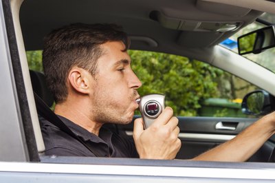 man blowing into breathalyzer