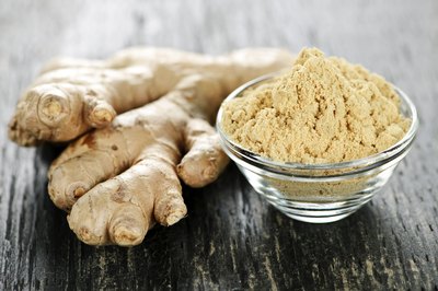 Ground ginger next to a ginger root.