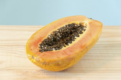 A sliced papaya on a cutting board.