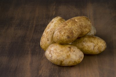 Pile of russet potatoes on tabletop.