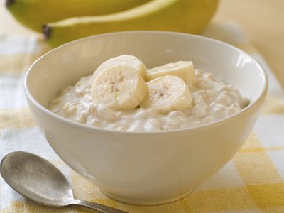 Bowl of oatmeal with sliced bananas.