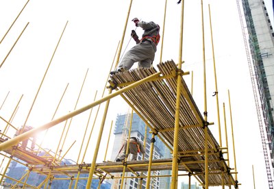 Workers on scaffolding wearing safety harnesses