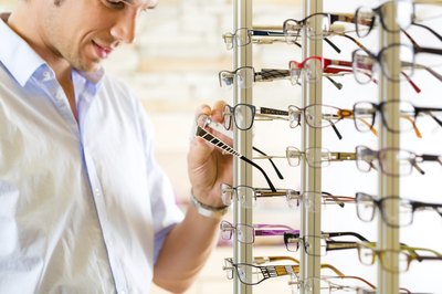 man looking at glasses