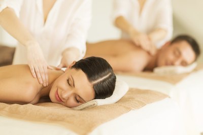 A couple getting massaged at a spa.