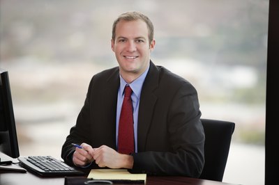 A software consultant smiling at an office desk.
