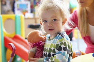 Girl playing with toy doll