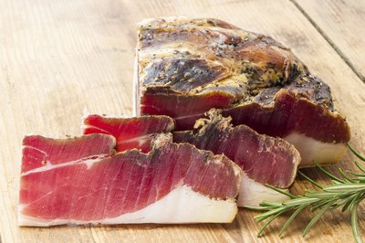 Slices of speck ham with rosemary