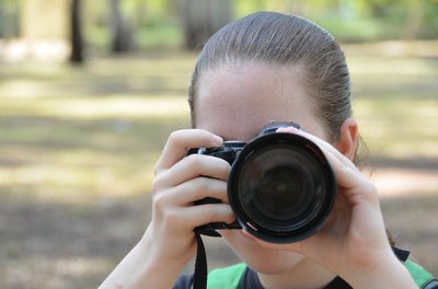 Teen girl takes photo with digital camera