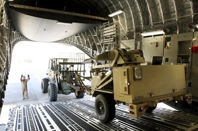 A ground surveillance radar unit is unloaded from a C-17 at Pope AFB
