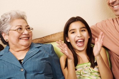 A girl sits with her family and applauses.