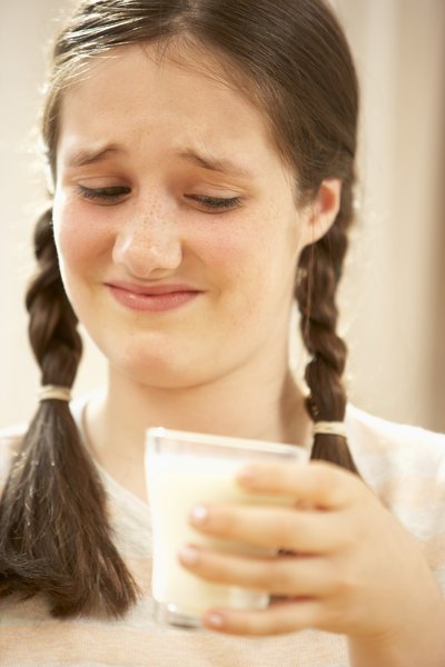 Girl frowning at glass of milk