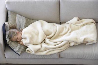 child sleeping with head elevated on couch pillow