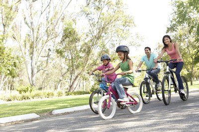 A young family riding bikes in the park.