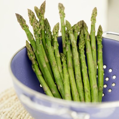 Asparagus drains in a colander.