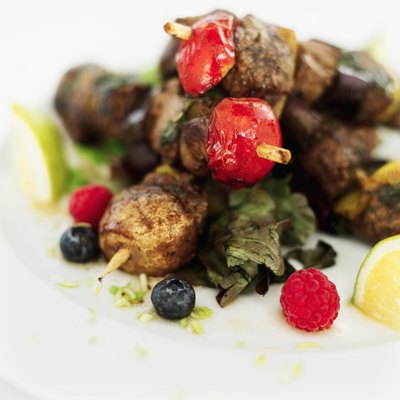 Skewers of meats vegetables on a plate.