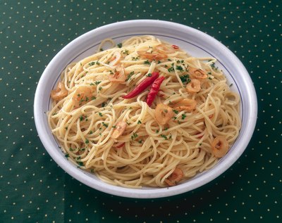 A bowl of pasta with shrimp and hot peppers.