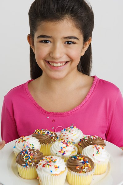 Girl holding cupcakes