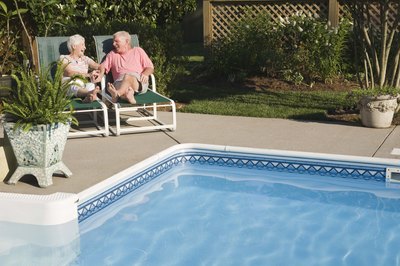 Senior couple sitting by swimming pool