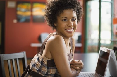 A woman working on her laptop in a cafe.