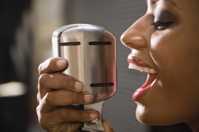 A woman sings into a microphone.