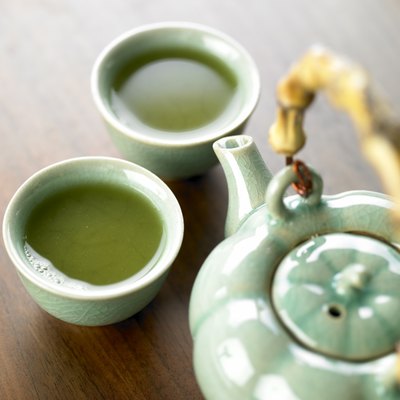 Pot and cups filled with green tea