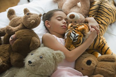 Girl sleeping with stuffed animals