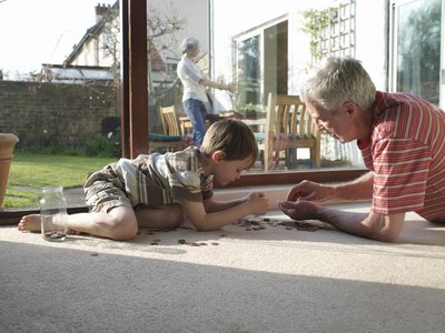 Grandson and Grandfather counting coins on floor