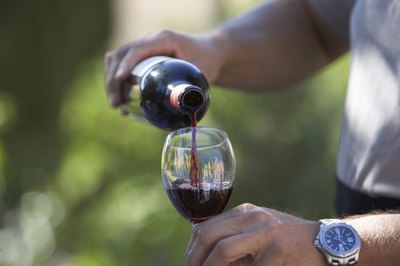 A man pouring a glass of red wine