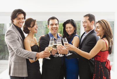 Couples in fancy clothes are toasting with wine glasses.