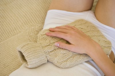 Woman holding hot water bottle on stomach