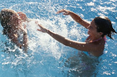 Teenage friends playing in pool