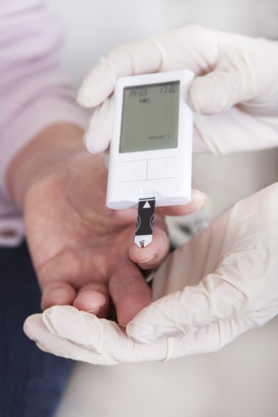 Doctor tests patient's blood sugar level