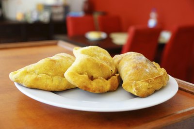 A plate of pastelitos de carne served on the counter in a restaurant.