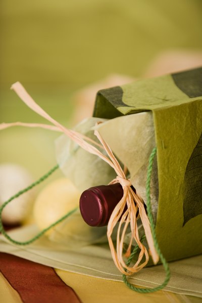 A bottle of wine tipped on its side in a gift bag.