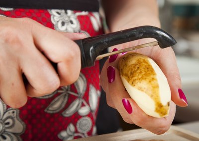 A woman peeling a potatoe