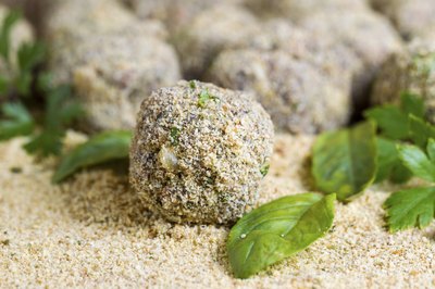 A close-up of ground beef mixed with bread crumbs, herbs and spices and rolled into balls.