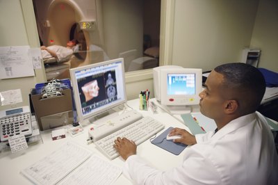Technician looking at MRI on computer screen