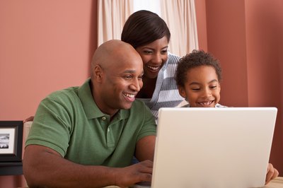 Man looking at laptop with family