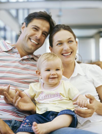 A family poses for a photo on the couch.