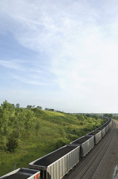 A train is carrying cars full of coal.
