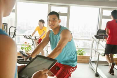 A young man is riding a stationary bike.