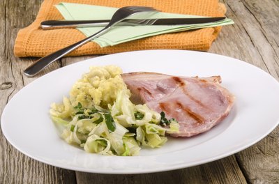 A plate of Irish bacon and cabbage on an outdoor table.