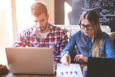 A couple working at a home on a laptop