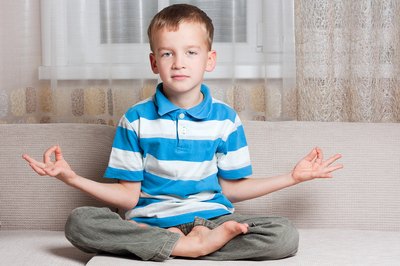 Small boy sits in a lotus position