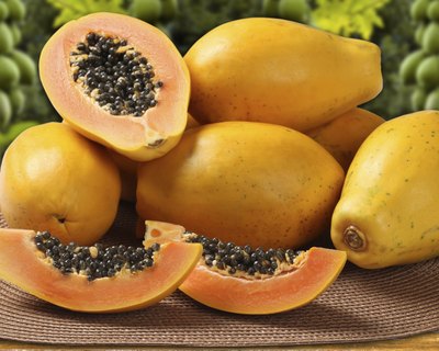 Whole and sliced papayas on a table